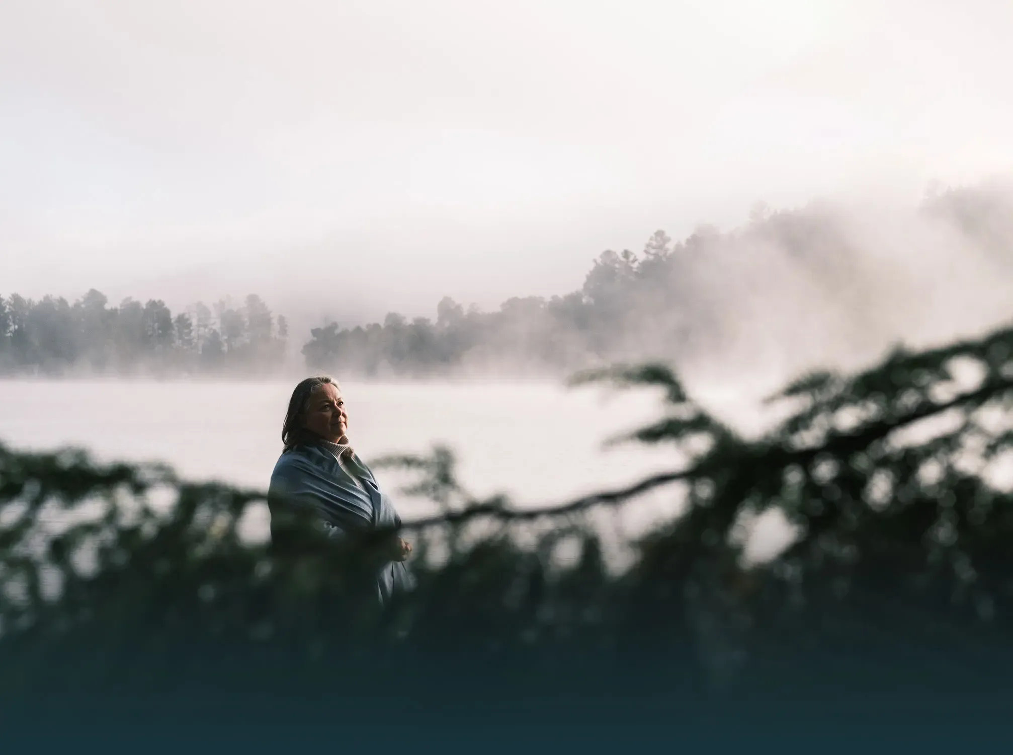 Marie-Josée Tardif au bord d’un lac des Laurentides, au petit matin, dans la brume